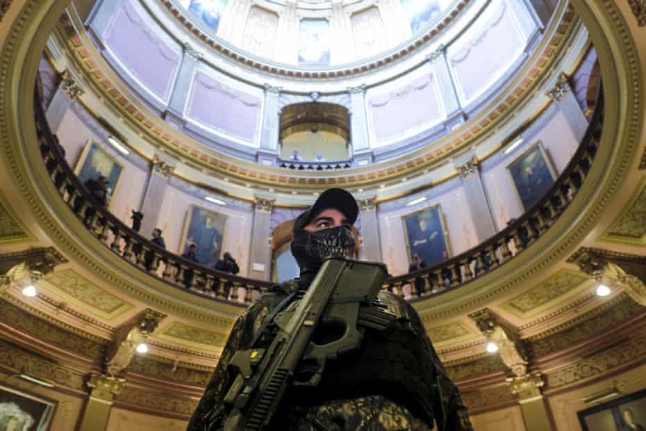 An armed protester wearing a mask stands at the Michigan capitol building in Lansing, Michigan, on 30 April.