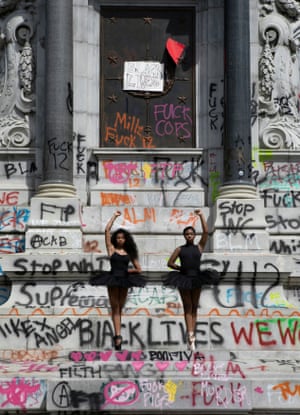 Ballerinas Kennedy George, 14, and Ava Holloway, 14, pose in front of a monument of Confederate general Robert E. Lee after Virginia Governor Ralph Northam ordered its removal.