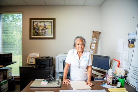 a woman stands behind a desk
