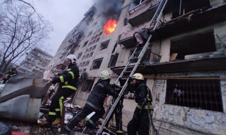 Firefighters work by a damaged apartment building hit by Russian attack in Kyiv