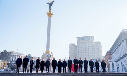 World leaders stand lined up at the top of a flight of steps in Kyiv, with the independence monument behind