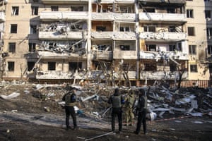 Ukrainian police inspect the site of a Russian bombing attack in front of a destroyed apartment building in Kyiv, Ukraine, on Tuesday 15 March