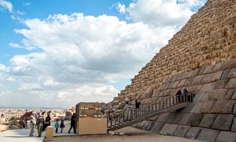 Visitors pose for a pictures at the base of the pyramid.