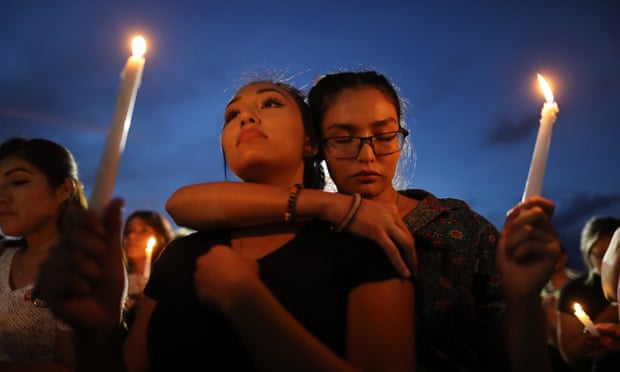 People attend a candlelight vigil at a makeshift memorial honoring victims of the El Paso shooting.