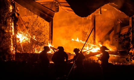 Firefighters tend to a structure lost during the Kincade fire east of Healdsburg, California.