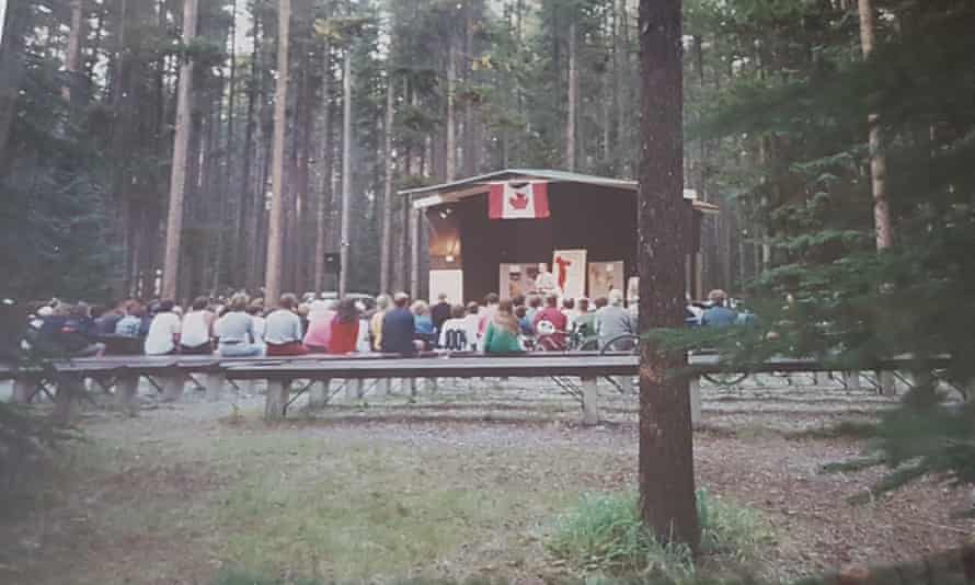 A park ranger gives a talk to a crowd in woods