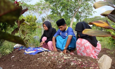 Iwan Junaedi’s children visit their father’s grave.