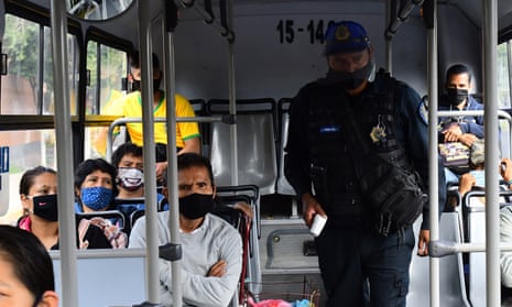 Officers check temperatures of bus passengers at a checkpoint in Mexico City.