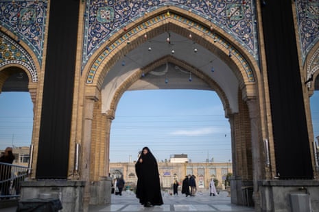 A veiled Iranian woman walks at a holy shrine