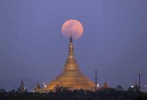 On the rise, the moon is photographed moving behind the Uppatasanti Pagoda, in Naypyitaw, Myanmar