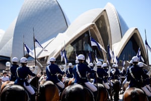 A group of police on horseback in uniform and helmets in front of the Sydney Opera House