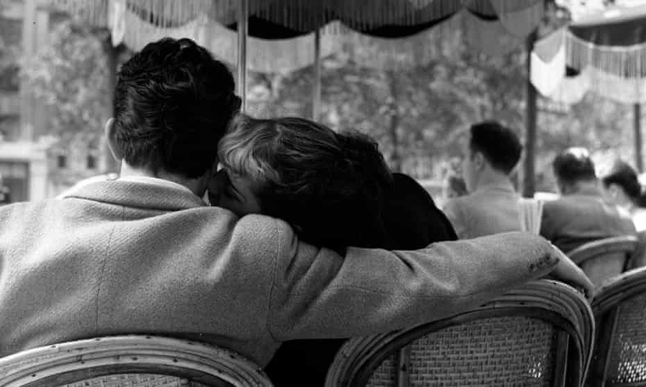 A young couple sharing an intimate moment in one of the pavement cafes on the Champs-Elysees, Paris in 1951