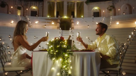 Ekin-Su and Davide raising their glasses in a toast, sitting at a table in an ampitheatre lit by candles on their final Love Island date.