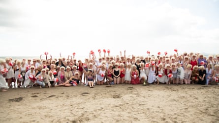 Scores of the Marilyn lookalikes pose in a long line on a beach