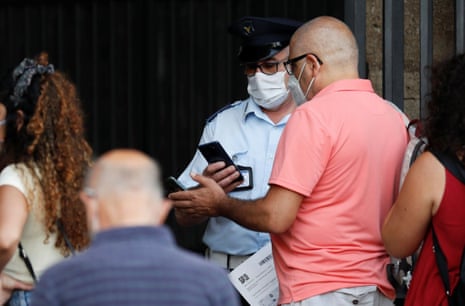 A tourist shows his ‘green pass’, which records proof of full vaccination, recovery from the virus, or a negative test, as he enters the Colosseum, in Rome, Italy.
