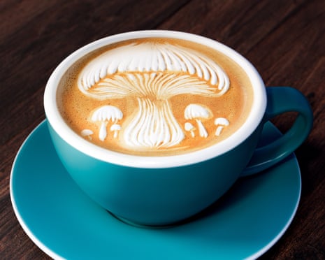 A cup of coffee with a mushroom design in the froth