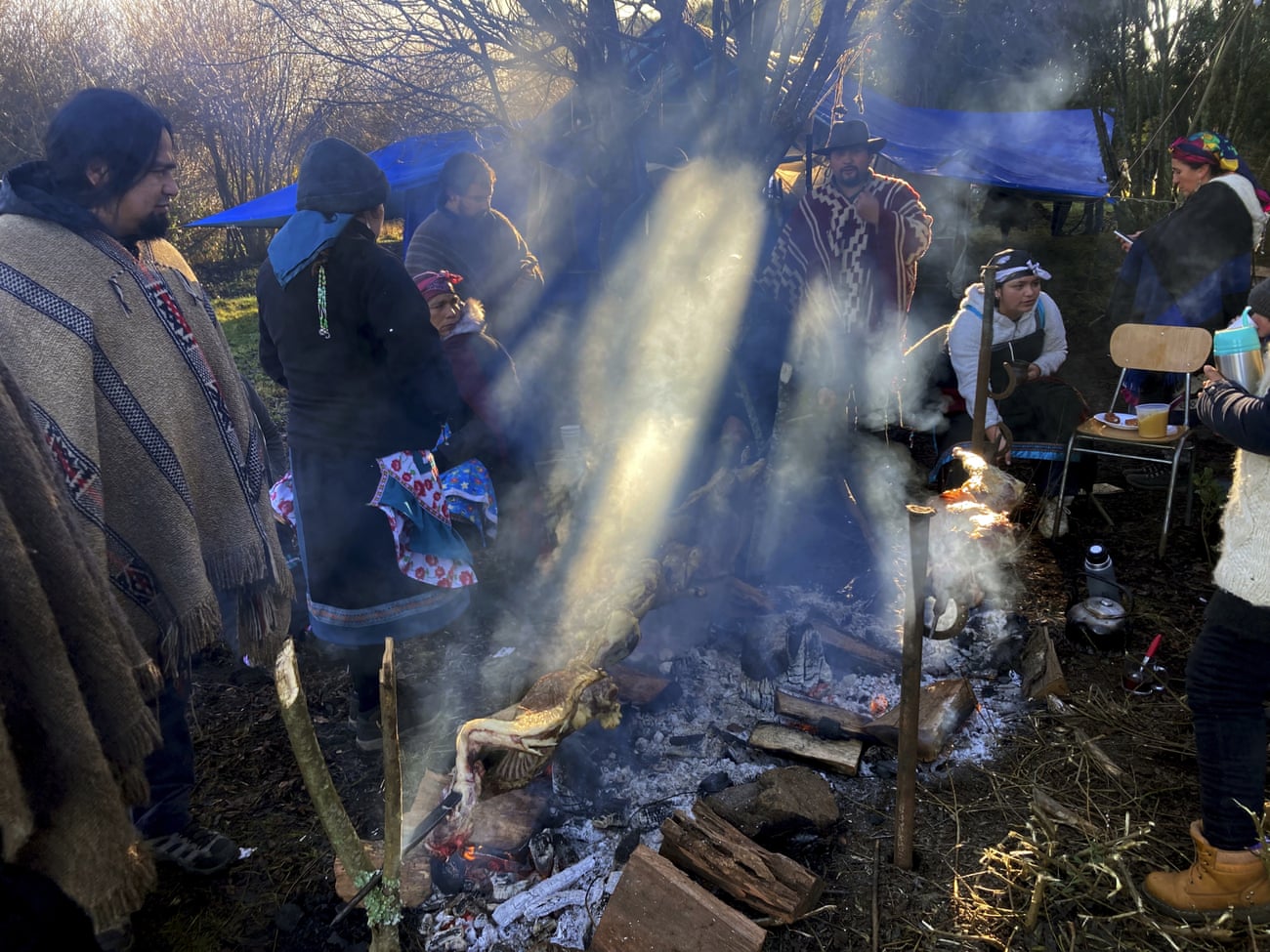 Members of the Mapuche Indigenous community gather while cooking a barbecue