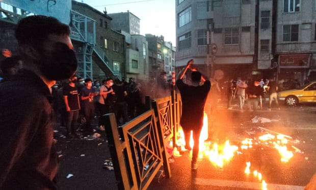 Protesters crowd behind a barrier in Tehran on 21 September.