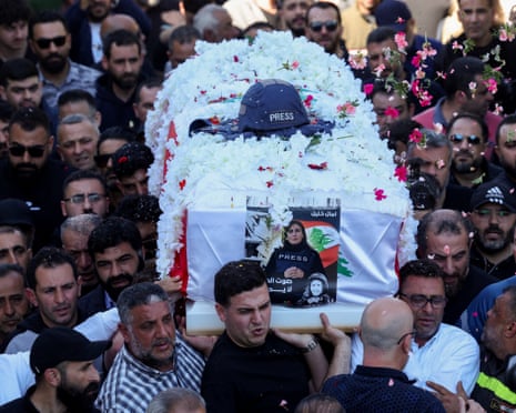 Flowers are thrown over the Amal Khalil’s coffin as mourners carry it during her funeral in Baisariyeh, Lebanon, on Thursday.