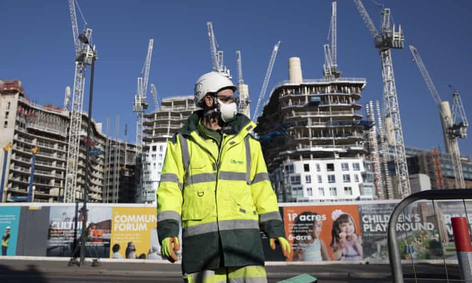 worker wearing a mask in front of a construction site