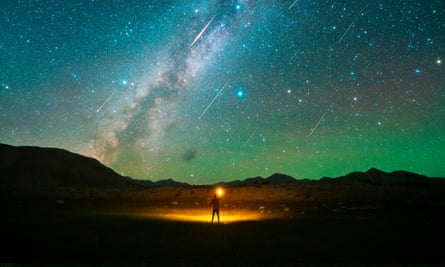 A man watches the Perseids meteor shower on the Pamir Plateau in Xinjiang Uygur Autonomous Region of China in 2021.