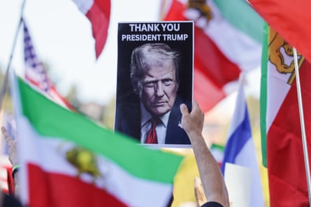 A demonstrators holds up a picture of Donald Trump in celebration following the US and Israeli strikes in Iran, in Los Angeles.
