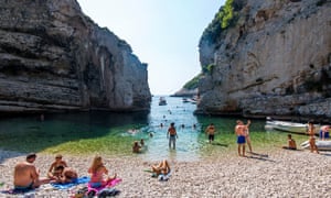 tourists swimming and sunbathing on Stiniva beach