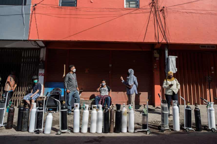 Residents queue up to get oxygen tanks refilled at a refilling station in Indonesia’s second-biggest city Surabaya.