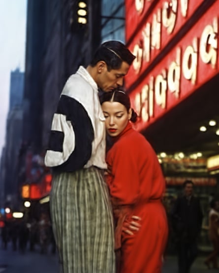 A man and woman embrace in a cityscape