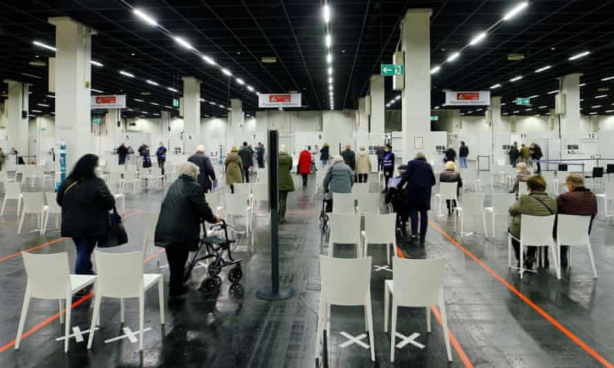 Les gens attendent de recevoir un vaccin Covid dans un centre temporairement installé dans un hall d'exposition à Cologne.