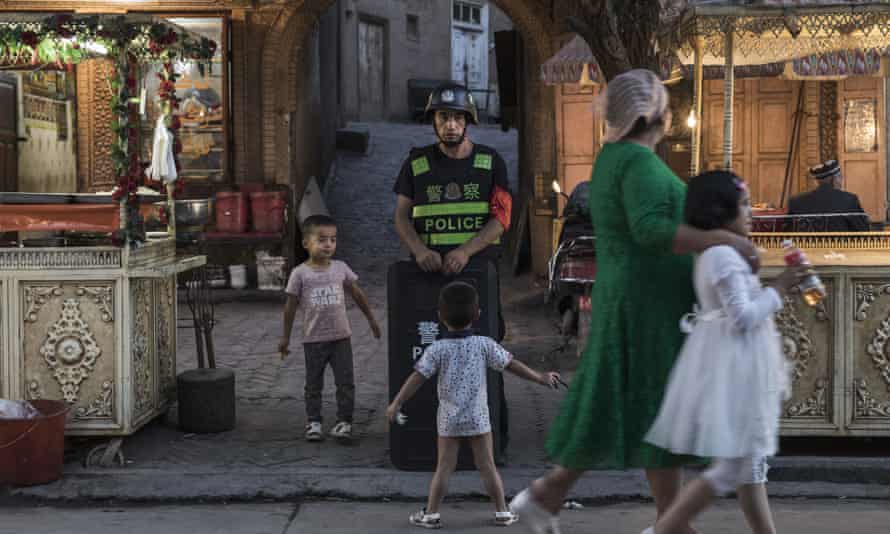 Uighur children taunt a local police officer in Kashgar.