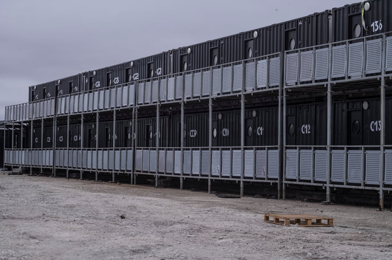 Black-painted shipping containers that have been made into housing