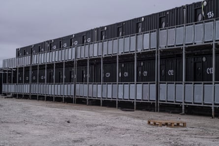 Black-painted shipping containers that have been made into housing