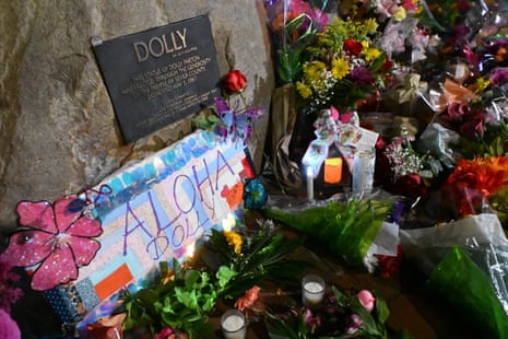 Flowers and a note left by fans are seen by the bronze statue of late US singer-songwriter Dolly Parton in downtown Sevierville, Tennessee on 25 August 2026.