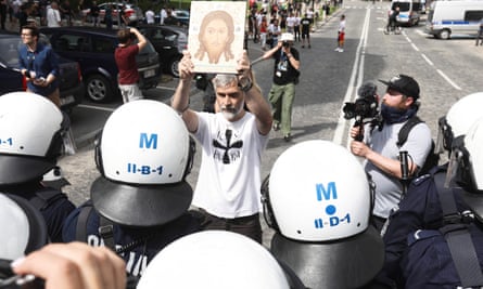 A man displays an image of Christ to mark his anti-Pride feelings.