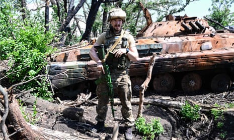 A Ukrainian soldier poses near the front line in eastern Ukraine, on 13 July.