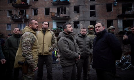 Volodymyr Zelenskiy with soldiers and others while visiting the site of a residential building destroyed by a Russian attack in Vyshhorod, near Kyiv