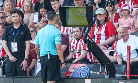 Andy Madley kiểm tra màn hình sau khi VAR đề nghị anh xem lại quyết định trong trận Sheffield United v Tottenham vào ngày 19 tháng 5.