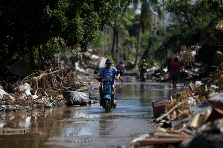 essay about mexico city A man rides a motorcycle down a street with piles of debris, a month after Hurricane Otis struck Acapulco.