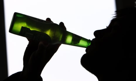 Silhouette of man drinking from bottle of beer