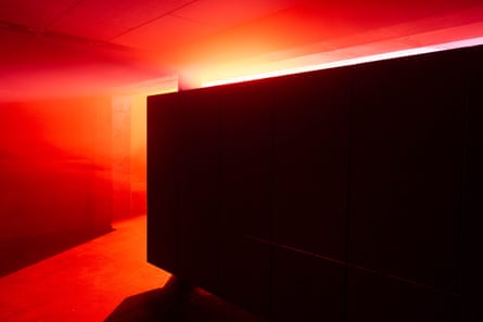 A dark cube against an orange and yellow background inside the club.