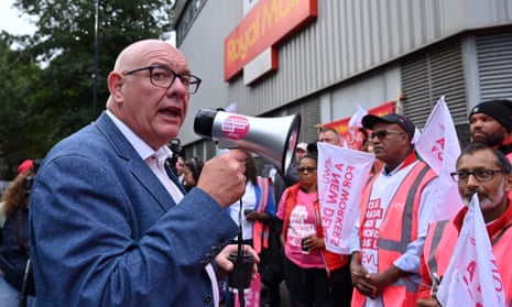 A photo of Dave Ward, general secretary of the Communication Workers Union, speaking in 2022 to Royal Mail postal workers as they stand on a picket line outside a delivery office.