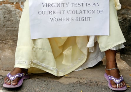 A protester holds a placard during a protest against virginity tests in New Delhi, India
