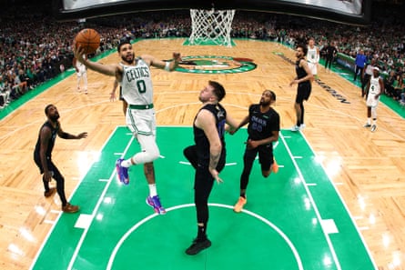 Jayson Tatum of the Celtics soars to the rim past Luke Dončić of the Mavericks during Thursday’s game.
