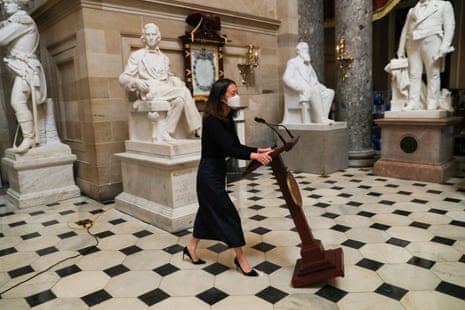 A staff member moves Nancy Pelosi’s lectern on Wednesday.