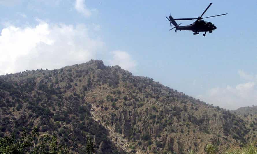 A US Ah-64 Apache helicopter manoeuvres over the mountains in the district of Manugay, Afghanistan.