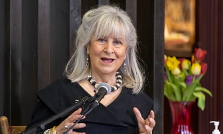 Woman with grey hair speaks into microphone.