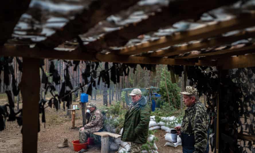 The older members of the Territorial Defense rest in the forest near the combat position.