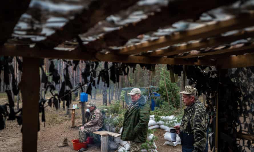 Older members of the Territorial defence have a rest in the forest near the combat position.