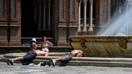 Two young men wetting their faces in a large fountain